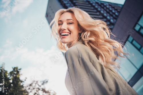 Profile side view portrait of attractive cheerful wavy haired girl having fun strolling enjoying sun light outside