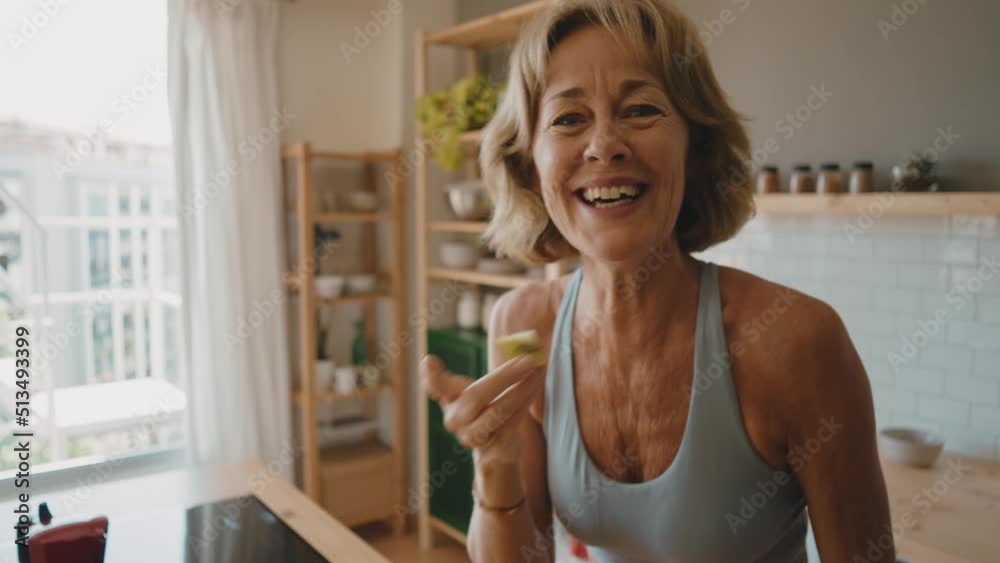 Beautiful senior woman preparing an healthy breakfast with fresh fruits early in the morning Beautiful senior woman preparing an healthy breakfast with fresh fruits early in the morning