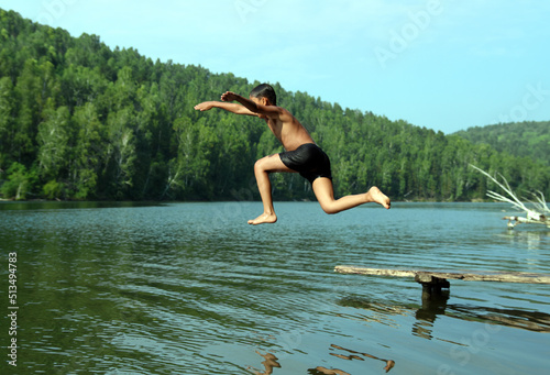 boy jumping in lake