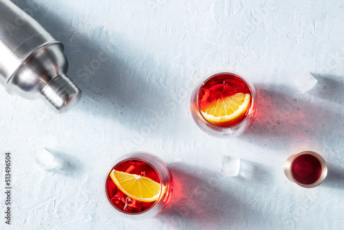 Campari orange cocktails with a jigger and a shaker, summer party drinks on ice with copy space, shot from the top