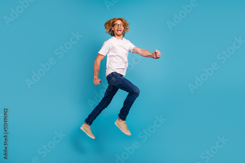 Full length photo of overjoyed active person jumping rush fast have good mood isolated on blue color background