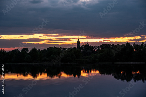 sunset on a large river with reflections in the water on a summer evening