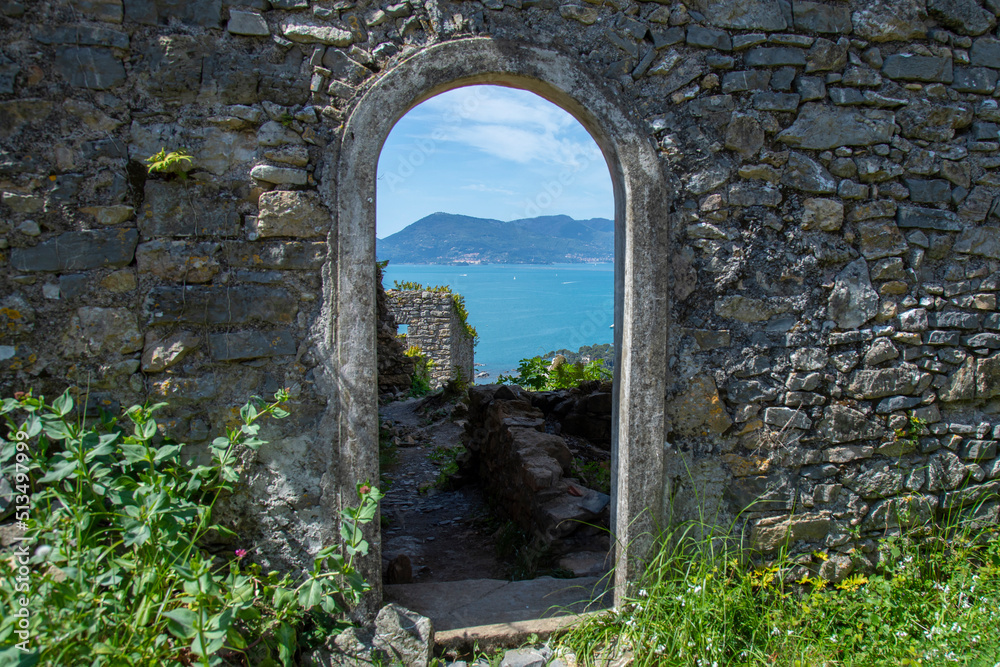 doorway in stone antique wall overlooking the sea