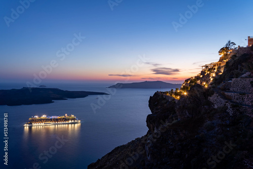 Santorini, Greece. 15.06.2022. View from Santorini (Fira town) on a beautiful bay and passenger ship at the sunset.