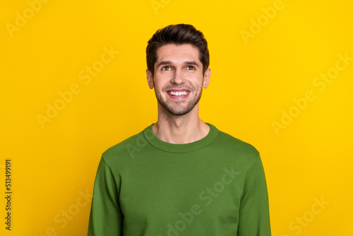 Photo of dreamy funny guy wear green sweater looking up empty space isolated yellow color background