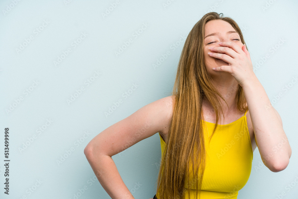 Fototapeta premium Young caucasian woman isolated on blue background laughing happy, carefree, natural emotion.