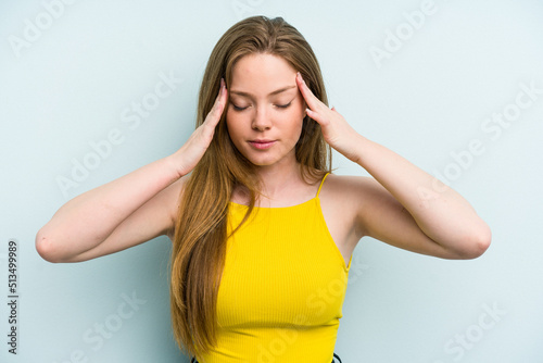 Young caucasian woman isolated on blue background touching temples and having headache.