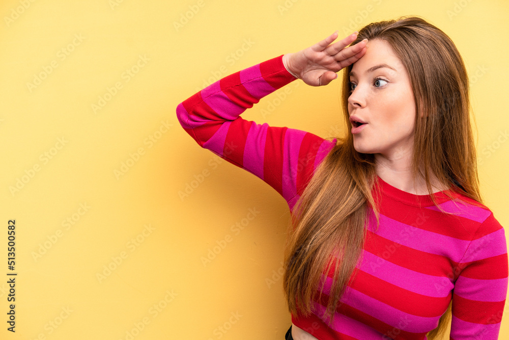 Young caucasian woman isolated on yellow background looking far away keeping hand on forehead. Young caucasian woman isolated on yellow background looking far away keeping hand on forehead.