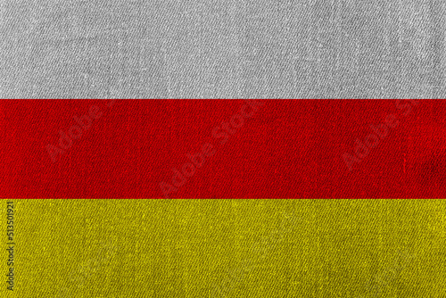 Patriotic classic denim background in colors of national flag. South Ossetia