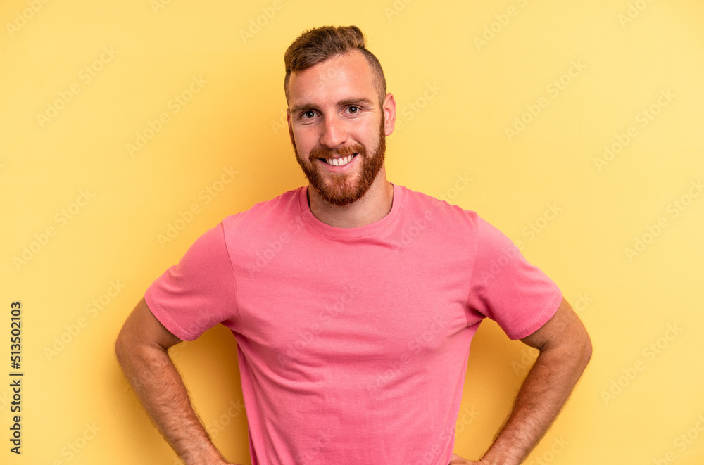Young caucasian man isolated on yellow background confident keeping hands on hips. Young caucasian man isolated on yellow background confident keeping hands on hips.