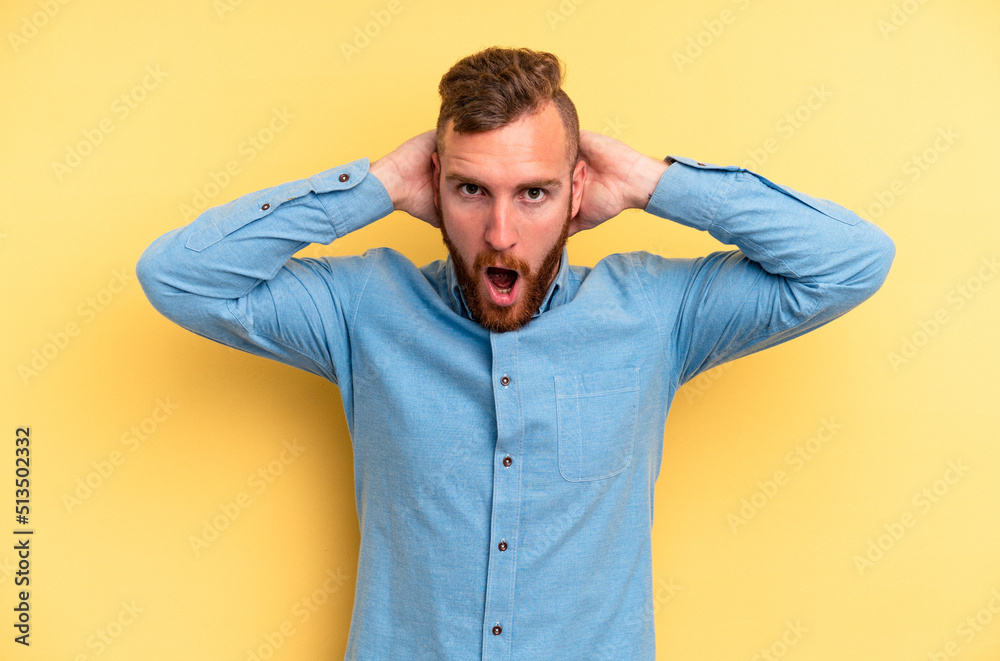 Young caucasian man isolated on yellow background screaming, very excited, passionate, satisfied with something. Young caucasian man isolated on yellow background screaming, very excited, passionate, satisfied with something.