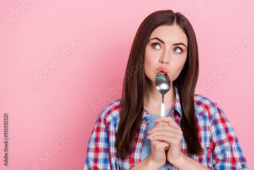 Portrait of charming dreamy lady looking blank space lick spoon thinking about food isolated on pink color background