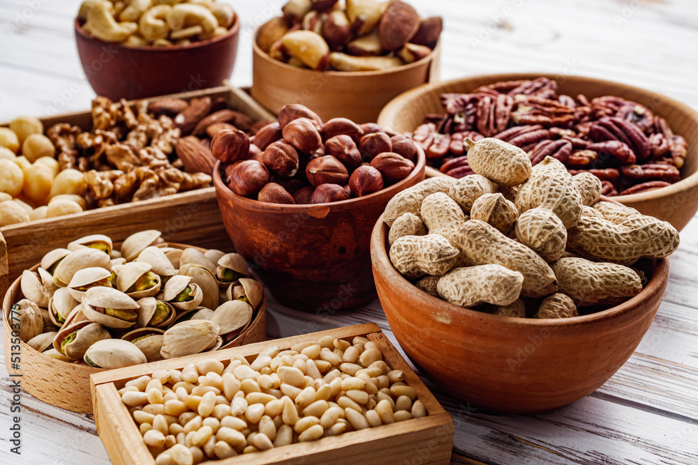 set of different nuts on a white wooden rustic background