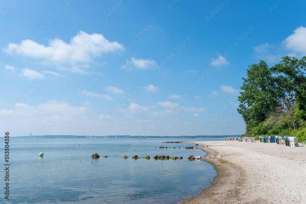 traditional beach chairs on baltic sea beach against blue sky on sunny summer day