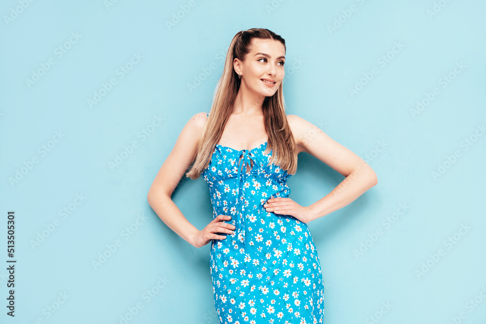 Portrait of young beautiful smiling female in trendy summer dress. Sexy carefree woman posing near blue wall in studio. Positive model having fun and going crazy. Cheerful and happy Portrait of young beautiful smiling female in trendy summer dress. Sexy carefree woman posing near blue wall in studio. Positive model having fun and going crazy. Cheerful and happy