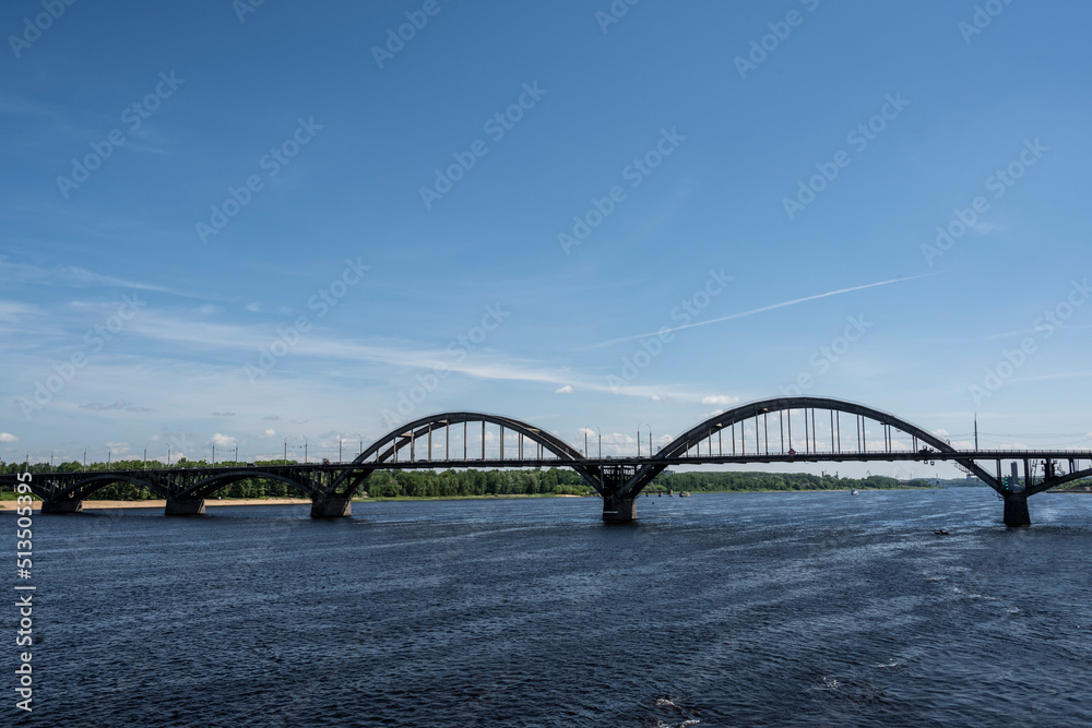 large metal railway bridge across the river against the blue sky