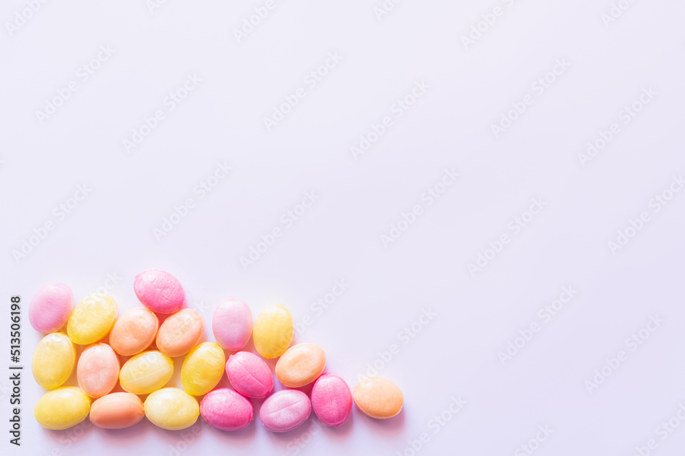Obraz premium Top view of colorful sweets on white background with copy space.
