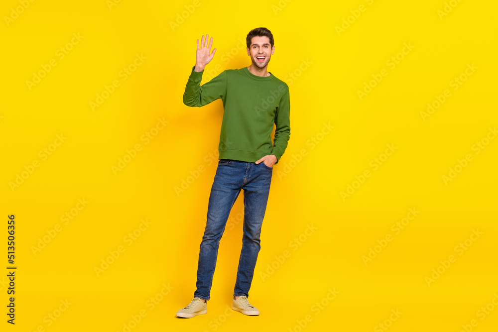 Fototapeta premium Photo of sweet attractive guy dressed green pullover smiling waving arm isolated yellow color background