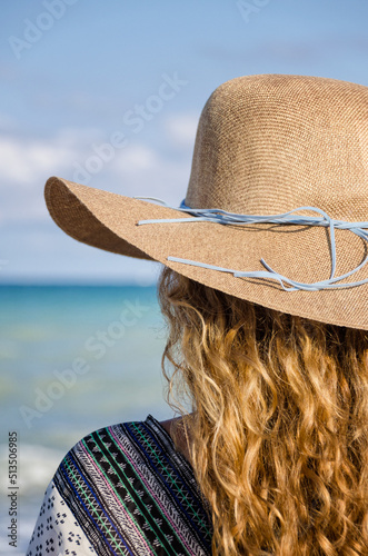 Chica con sombrero mirando al mar photo