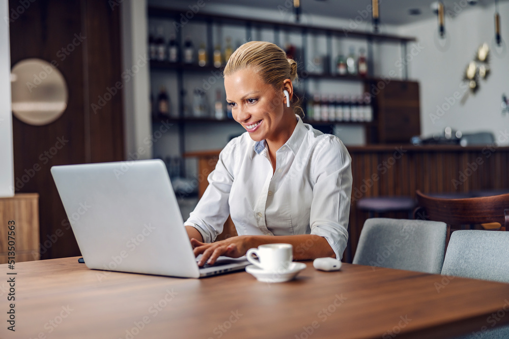 Fototapeta premium A businesswoman typing on laptop in cafe.