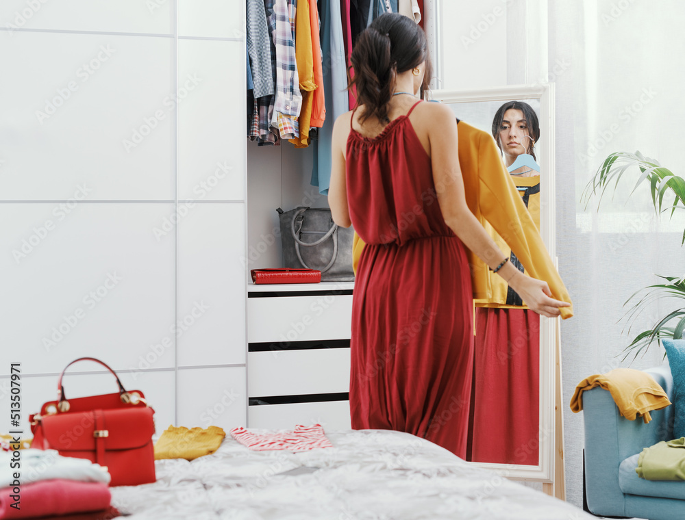 © StockPhotoPro - Woman choosing clothes in her bedroom