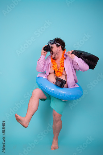 Vacation and holidays. Funny fat man is going to the sea. Guy with an inflatable circle.