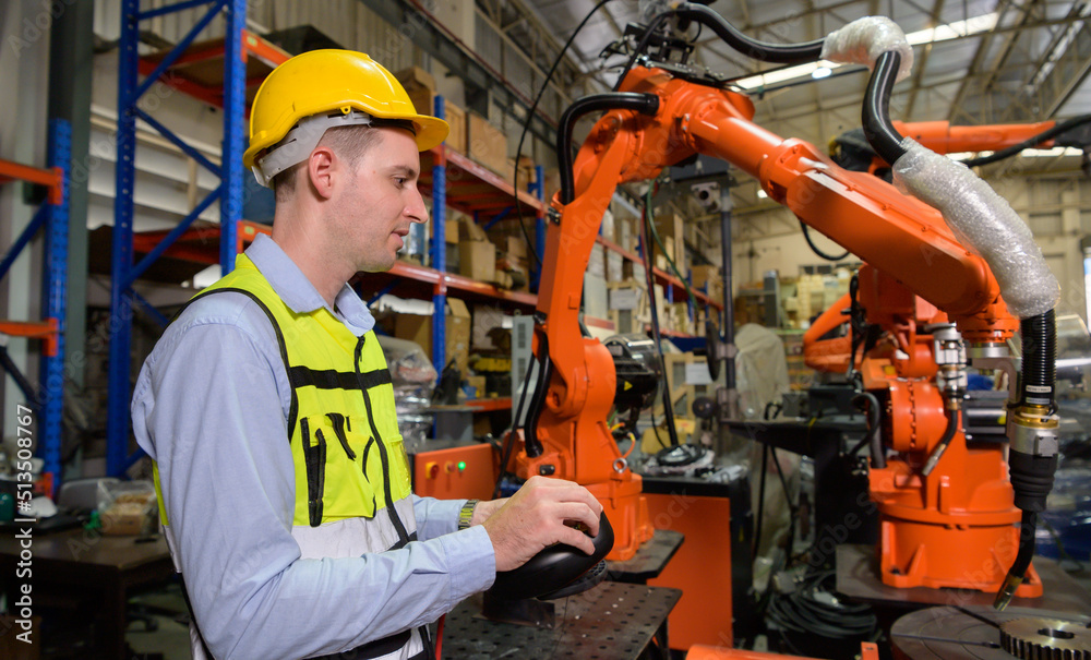 A male worker is controlling a welding robot. by using forcing welding with a control screen which is used for precision welding control. Fast and highly secure A male worker is controlling a welding robot. by using forcing welding with a control screen which is used for precision welding control. Fast and highly secure