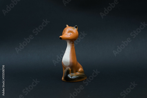 Vintage porcelain figurine - fox isolated on black background