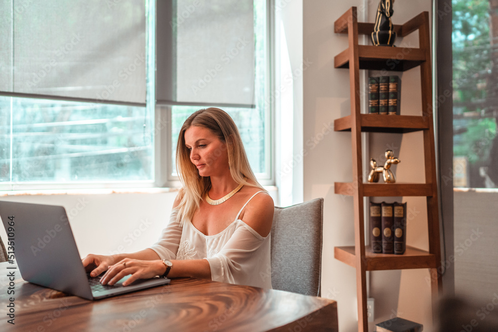 blonde girl working remotely from her computer blonde girl working remotely from her computer