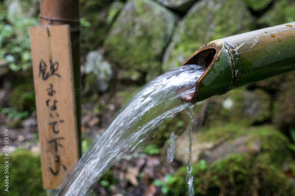 京都の庭園にて、竹から流れ出る水と注意書き