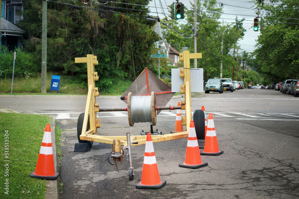Wire feeding rig at a construction site in Binghamton in Upstate NY.  Cable spool on a repair trailer with cones at an intersection.  