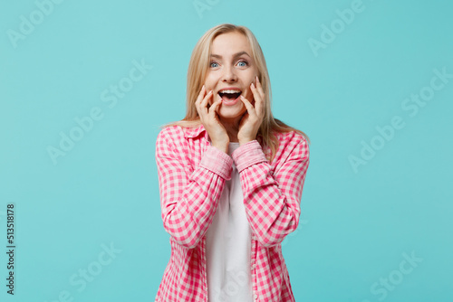 Young exultant surprised amazed happy cool caucasian woman she 30s wears pink shirt white t-shirt look camera hold face isolated on plain pastel light blue background studio. People lifestyle concept.