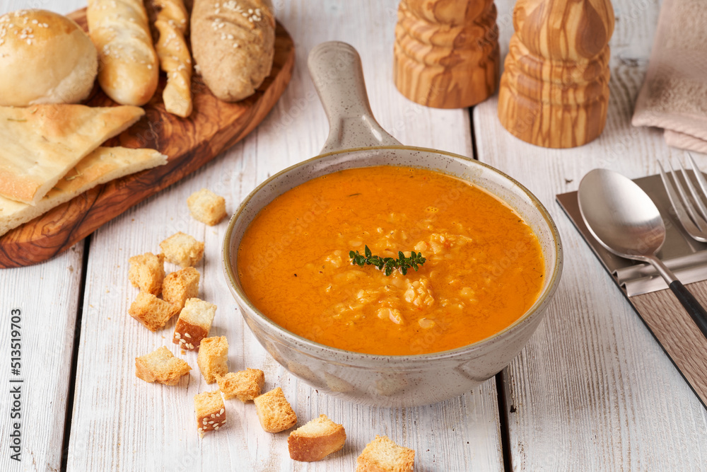 Composition with bowl with delicious carrot soup and croutons on wooden table. Composition with bowl with delicious carrot soup and croutons on wooden table.