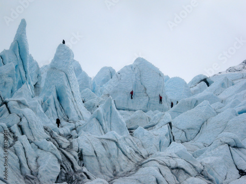 Unrecognizable people ice climbing seracs on the Matanuska Glacier in the fall