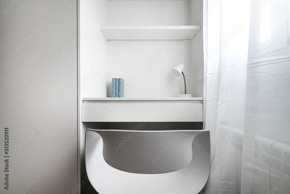 Small white wooden study table with resin and wood shelves and chair, small lamp and decorative objects Small white wooden study table with resin and wood shelves and chair, small lamp and decorative objects