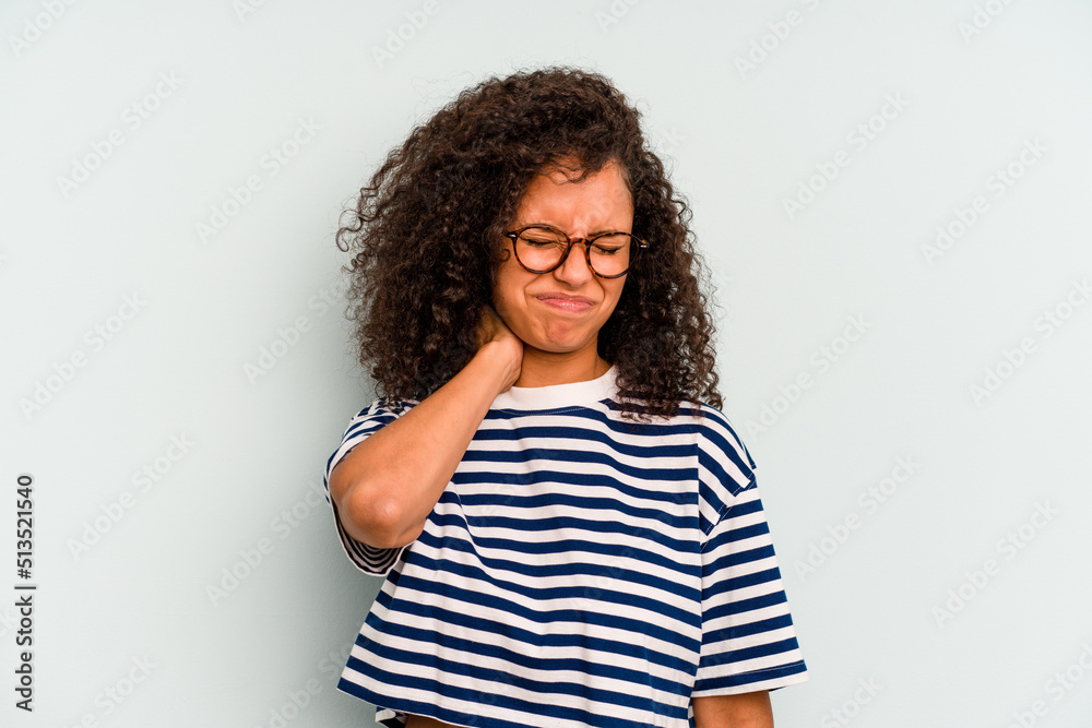 Young Brazilian woman isolated on blue background having a neck pain due to stress, massaging and touching it with hand.