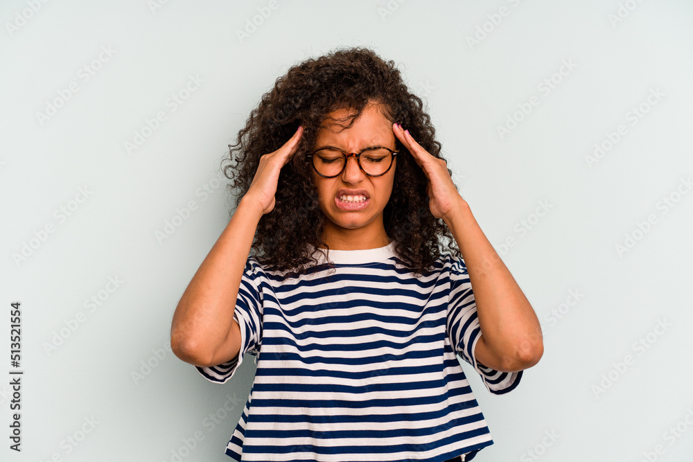 Young Brazilian woman isolated on blue background touching temples and having headache. Young Brazilian woman isolated on blue background touching temples and having headache.