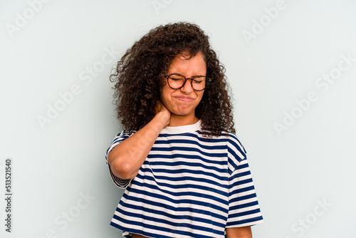 Young Brazilian woman isolated on blue background having a neck pain due to stress, massaging and touching it with hand. © Asier