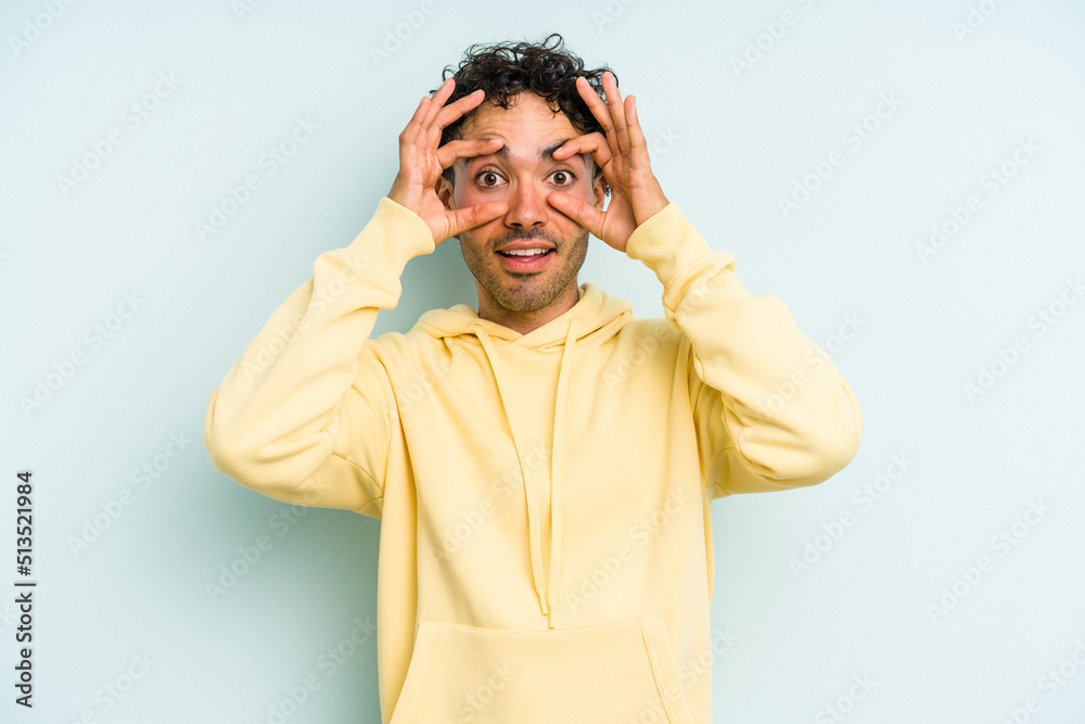 Young caucasian man isolated on blue background keeping eyes opened to find a success opportunity. Young caucasian man isolated on blue background keeping eyes opened to find a success opportunity.