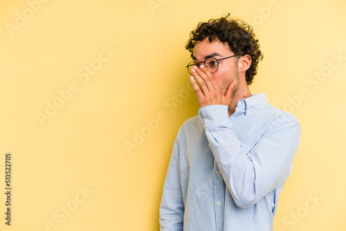 Young caucasian man isolated on yellow background being shocked because of something she has seen.
