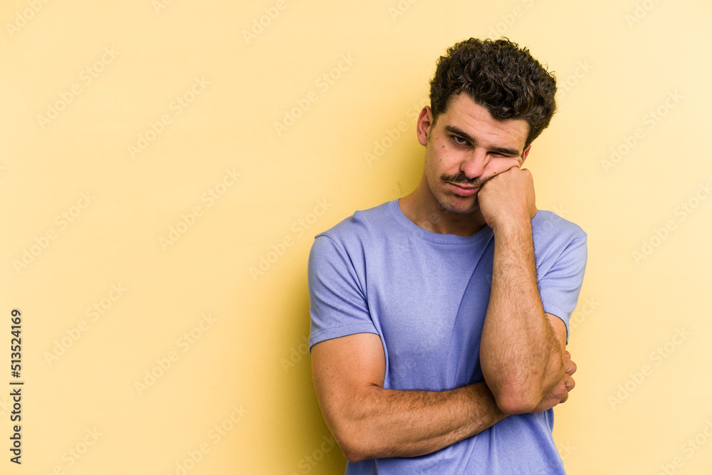 Young caucasian man isolated on yellow background who feels sad and pensive, looking at copy space.