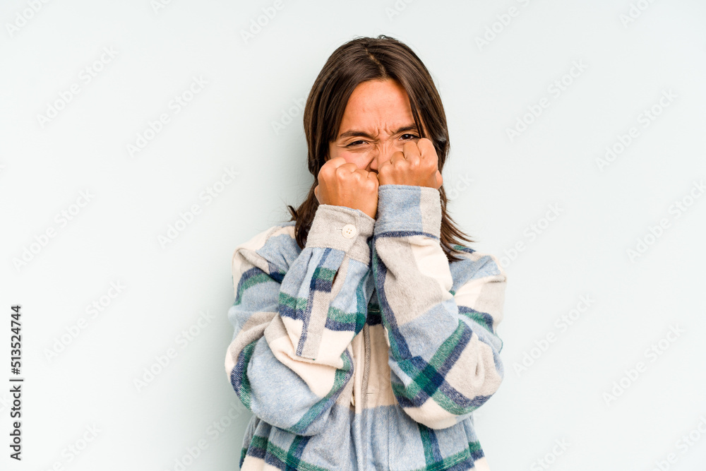 Young hispanic woman isolated on blue background rejecting someone showing a gesture of disgust. Young hispanic woman isolated on blue background rejecting someone showing a gesture of disgust.