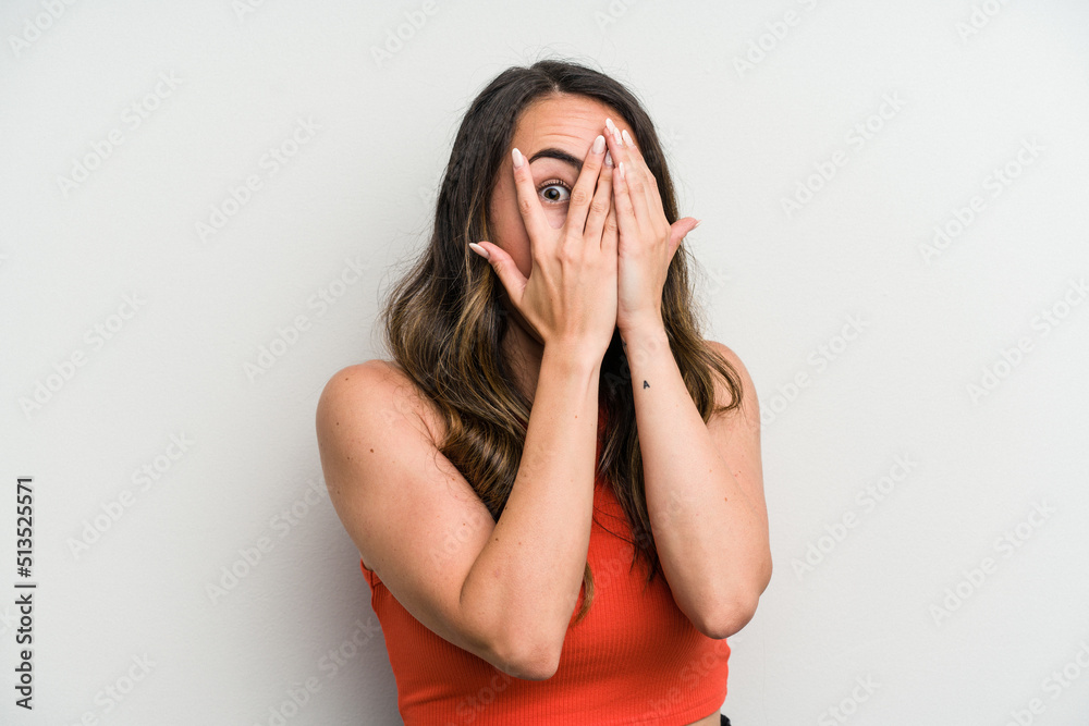 Young caucasian woman isolated on white background blink through fingers frightened and nervous. Young caucasian woman isolated on white background blink through fingers frightened and nervous.