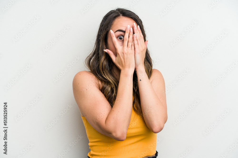 Young caucasian woman isolated on white background blink through fingers frightened and nervous. Young caucasian woman isolated on white background blink through fingers frightened and nervous.
