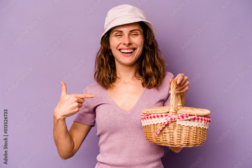 Young caucasian woman going on a picnic isolated on purple background person pointing by hand to a shirt copy space, proud and confident Young caucasian woman going on a picnic isolated on purple background person pointing by hand to a shirt copy space, proud and confident