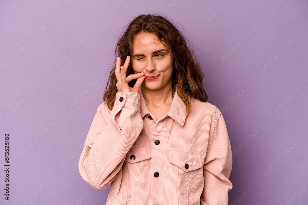 Young caucasian woman isolated on purple background with fingers on lips keeping a secret. Young caucasian woman isolated on purple background with fingers on lips keeping a secret.