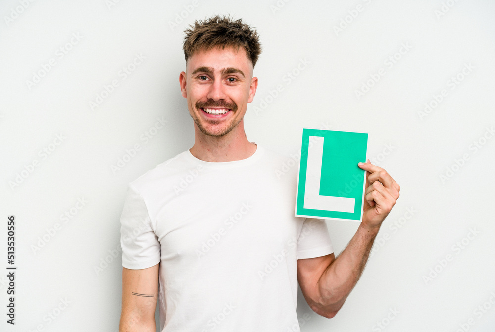 Young caucasian man holding L placard isolated on white background happy, smiling and cheerful. Young caucasian man holding L placard isolated on white background happy, smiling and cheerful.