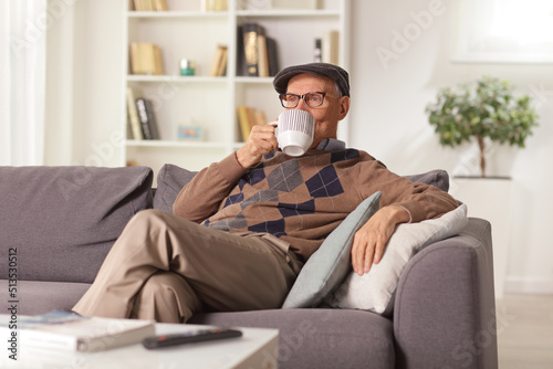 Elderly man relaxing on a sofa at home and drinking tea © Ljupco Smokovski