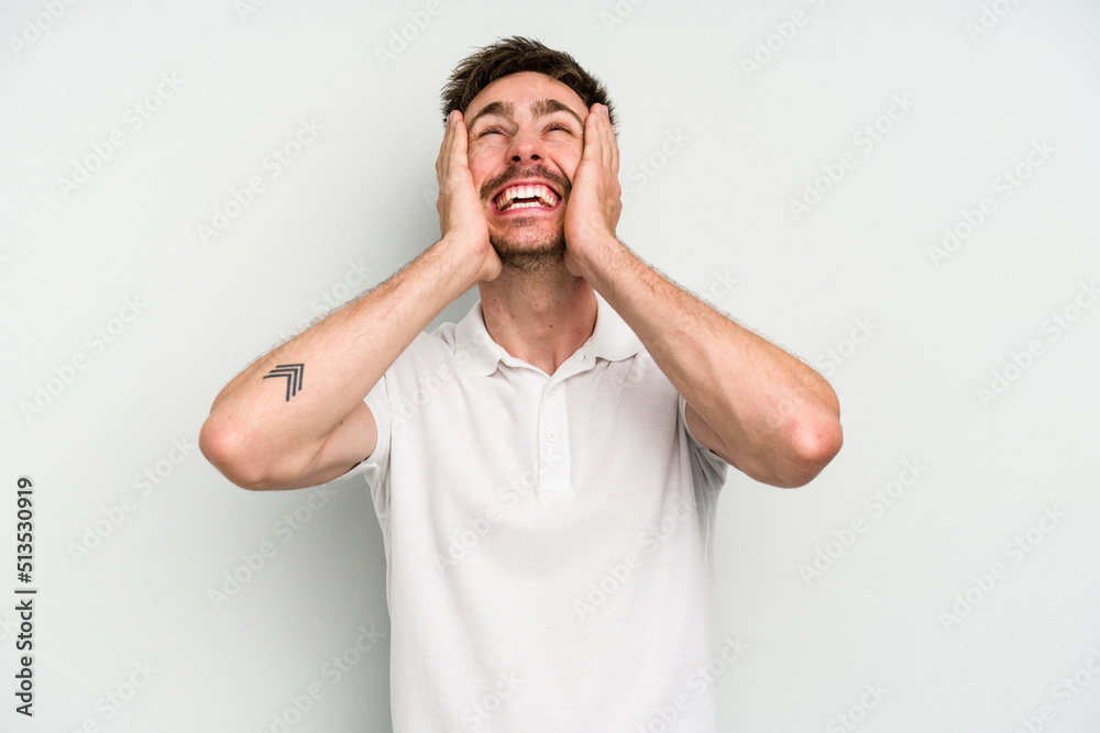 Young caucasian man isolated on white background laughs joyfully keeping hands on head. Happiness concept. Young caucasian man isolated on white background laughs joyfully keeping hands on head. Happiness concept.