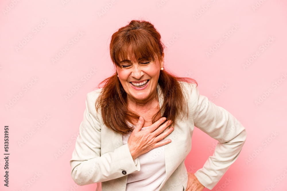 Middle age caucasian woman isolated on pink background laughing keeping hands on heart, concept of happiness. Middle age caucasian woman isolated on pink background laughing keeping hands on heart, concept of happiness.